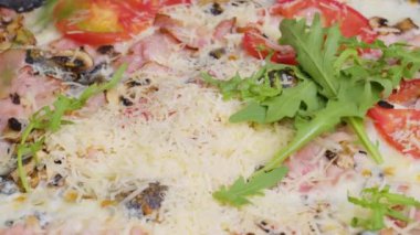 Pişmiş pizzaya taze kişniş serpiştiren bir şefin yakın plan görüntüsü. Yeni pişmiş pizzaya garnitür serpiyorum. İzolasyon döneminde evde yemek pişirmek, 2021 salgını. Evde kal konsepti.