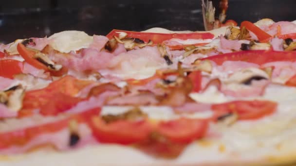 Corte de pizza com uma faca redonda. Close-up de pizza deliciosa sendo cortada em pedaços. — Vídeo de Stock