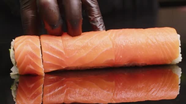 Sushi Chef Rebanadas de sushi en el bar de sushi. Un sushi-man cortando una con su cuchillo japonés. Preparando pescado nigiri de sushi. Recetas de cocina japonesa. — Vídeos de Stock
