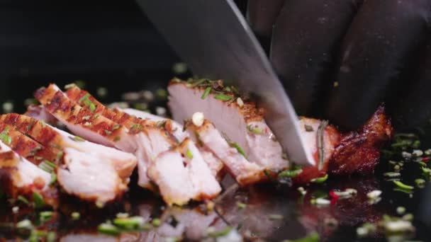 Nahaufnahme eines saftigen frisch gegrillten Steaks direkt vom Grill, das mit Gabel und Messer auf dem Küchentisch geschnitten wird. — Stockvideo