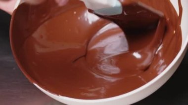 Yakın plan karıştırılmış çikolata, metal hamur kaşığı, erimiş sıcak çikolata. El yapımı çikolatalı tatlı ve şeker pişirmek. Şekerlemeci.