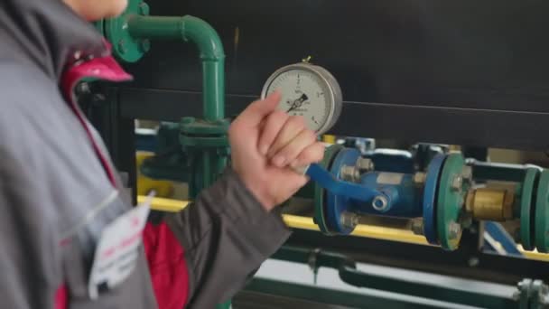 Palanca y medidor de presión con tubos delgados cerca de la pared metálica en taller de planta brillantemente iluminado vista cercana extrema. — Vídeos de Stock