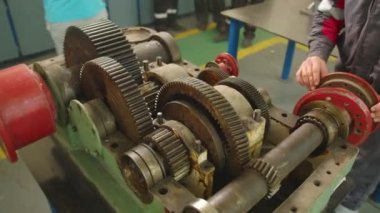 Vites kutusunu aç. Vitesler dönüyor. İletişim kontrolü ve onarım. İletme vitesleri yakın çekim ayrıntıları. Döndürme hareketini yakın çekim yap. Fabrika, tamir atölyesi