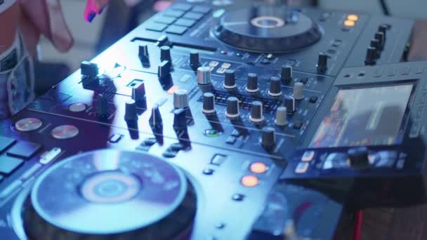 Ferme là. console de contrôle sonore DJ pour mixer de la musique de danse dans un club disco. Toucher les mains boutons curseurs, jouer de la musique électronique sur le pont de mélange, illumination des couleurs dans la soirée de danse de boîte de nuit. — Video