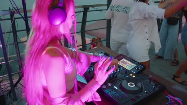 Cool DJ arbetar i en nattklubb, står vid skivspelare, skapa en dans musik set - nattliv koncept 4k film. — Stockvideo