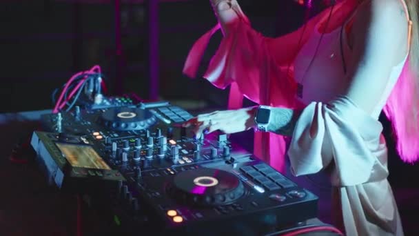 DJ-händer styr ljudkonsolen för att blanda musik i discoklubben. Stäng i slow motion. Fingrarna vidrör knappar, spelar elektronisk musik på däck. Färg ljus show i nattklubb dans fest. — Stockvideo