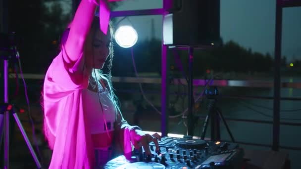 Cool dj arbejder i en natklub, stående på pladespillere, skabe en dans musik sæt - natteliv koncept 4k optagelser. – Stock-video