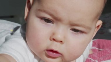 Güzel, küçük bir bebek kameraya gülümsüyor, yumuşak bir odak arkaplanı var..