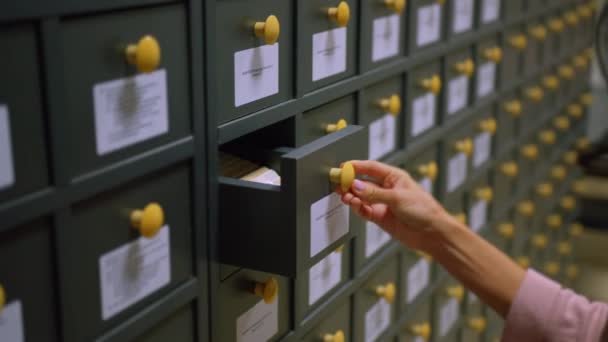 Femme dans une vieille archive vintage. Fouillez le système de fichiers. Rechercher des documents dans l'index des cartes, gros plan. — Video