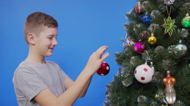Szczęśliwy mały chłopiec dekorowanie choinki z kulkami. — Wideo stockowe