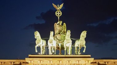 Berlin, Almanya -15.08.2025: Brandenburg Kapısı 'ndaki Quadriga heykeli akşam saatlerinde aydınlandı, Berlin. Almanya.