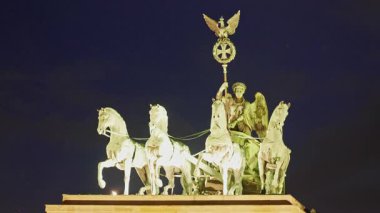Berlin, Almanya -15.08.2025: Brandenburg Kapısı 'ndaki Quadriga heykeli akşam saatlerinde aydınlandı, Berlin. Almanya.