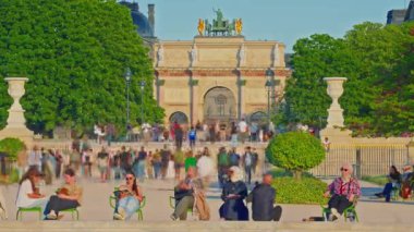 Tuileries Gardenin, Paris, Fransa. İnsanlar parkta yürüyor ve çeşmenin yanındaki sandalyelerde oturuyorlar. Zaman aşımı. Paris, Fransa, 30.05.2025.