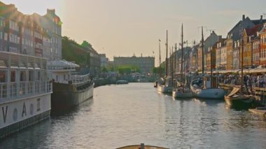Kopenhag, Danimarka - 21.08.2025: Günbatımında ünlü kanal boyunca turist taşıyan bir tekne.