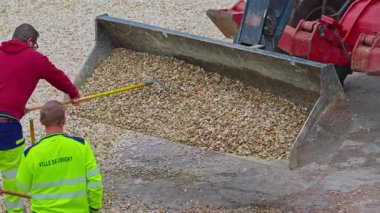 Joigny, Fransa - 25.09.2025: İşçiler çakılları eşitlemek için kürek kullanıyor. Arka bahçede yaya yollarının inşaatı. Geleneksel çevre dostu kaldırımlar Fransa 'da ince çakıllı.