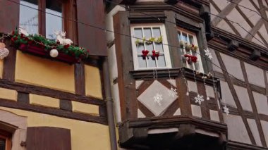 Eguisheim, Fransa - 3.12.2025: Noel için dekore edilmiş küçük, güzel bir köy. İnsanlar güzel dekore edilmiş Fransız köyü Eguisheim sokaklarında geziniyor..