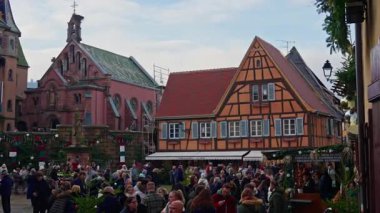 Eguisheim, Fransa - 3.12.2025: Noel için dekore edilmiş küçük, güzel bir köy. İnsanlar güzel dekore edilmiş Fransız köyü Eguisheim sokaklarında geziniyor..