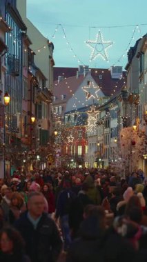 Colmar, Fransa - 3.12.2025: Akşamları Noel ve Yeni Yıl sokak dekorasyonları. Noel pazarı Colmar, Alsace, Fransa. Dikey video.