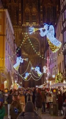 Strasbourg, Fransa - 1 Aralık 2025: Strazburg 'da Noel' in kalbinde Noel pazarı. Strasbourg Katedrali. Dikey video.