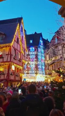 Colmar, Fransa - 03.12.2025: Colmar 'da Noel için akşam saatlerinde güzel sokak dekorasyonları aydınlatması. Noel pazarı Colmar, Alsace, Fransa. Dikey video.