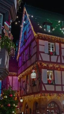 Colmar, Fransa - 03.12.2025: Colmar 'da Noel için akşam saatlerinde güzel sokak dekorasyonları aydınlatması. Noel pazarı Colmar, Alsace, Fransa. Dikey video.