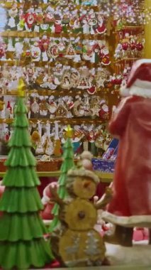 Fransa 'nın Strazburg kentindeki Yeni Yıl Pazarı' nda yılbaşı hediyeleriyle aydınlatılmış mağaza vitrinleri. Dikey video.