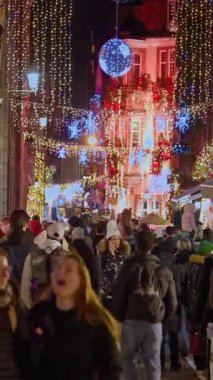 Colmar, Fransa - 3.12.2025: Akşamları Noel ve Yeni Yıl sokak dekorasyonları. Noel pazarı Colmar, Alsace, Fransa. Dikey video.
