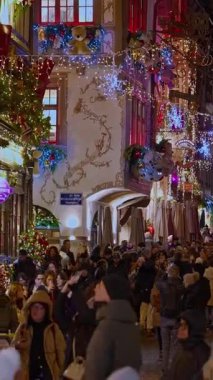 Colmar, Fransa - 3.12.2025: Akşamları Noel ve Yeni Yıl sokak dekorasyonları. Noel pazarı Colmar, Alsace, Fransa. Dikey video.