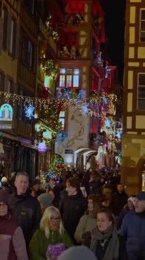 Colmar, Fransa - 3.12.2025: Akşamları Noel ve Yeni Yıl sokak dekorasyonları. Noel pazarı Colmar, Alsace, Fransa. Dikey video.