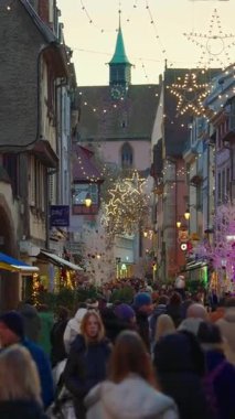 Colmar, Fransa - 3.12.2025: Akşamları Noel ve Yeni Yıl sokak dekorasyonları. Noel pazarı Colmar, Alsace, Fransa. Dikey video.