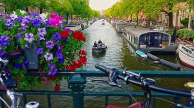 Amsterdam, Netherlands August 20, 2025: Amsterdam canal, bicycles and bridges with flowers .