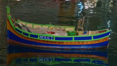 Geleneksel bir Malta gemisi Luzzu gece aydınlatmayla St. Julians Körfezi 'ne demir attı..