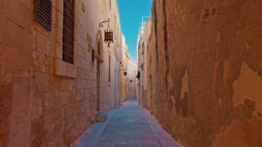 Malta 'daki Mdina kasabası kireçtaşından yapılma dar bir ortaçağ caddesinde yürüyor..
