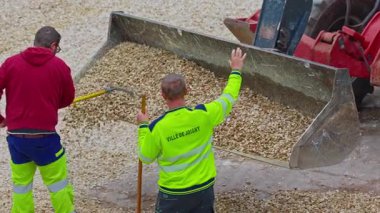 Joigny, Fransa - 25.09.2025: İşçiler çakılları eşitlemek için kürek kullanıyor. Arka bahçede yaya yollarının inşaatı. Geleneksel çevre dostu kaldırımlar Fransa 'da ince çakıllı.