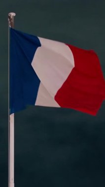 Fransız bayrağı alacakaranlıkta rüzgarda dalgalanıyor..