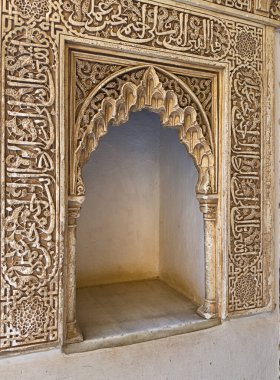 Granada, İspanya - 24 Ekim 2025: İspanya 'nın Granada kentindeki Nasrid Sarayı' nda İslami metinlerle zengince dekore edilmiş bir taş çerçeveyle çevrili bir kemer.