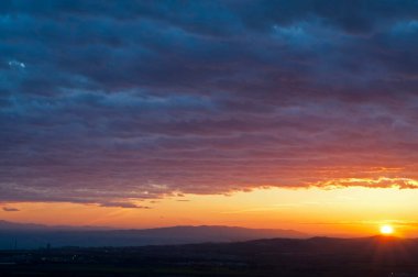 Arkaplan için dağların üzerinden gün batımının manzaralı görüntüsü