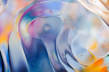 Su yüzeyindeki yağ damlacıklarının hareketine yakın çekim. Su yüzeyindeki yağ damlalarının renkli ve soyut makro arkaplanı