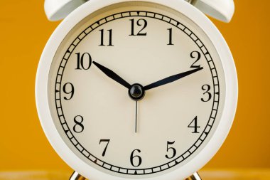 sarı arkaplanda bej rengi alarm saati.