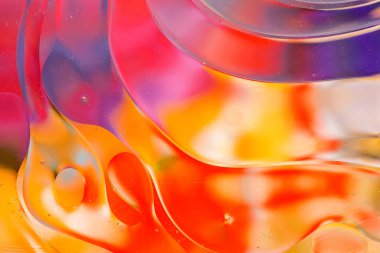 Su yüzeyindeki yağ damlacıklarının hareketine yakın çekim. Su yüzeyindeki yağ damlalarının renkli ve soyut makro arkaplanı