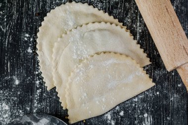 Çiğ et ve çiğ cheburekler, ahşap bir masada kızartılmak üzere pişirilir..