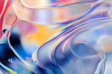 Su yüzeyindeki yağ damlacıklarının hareketine yakın çekim. Su yüzeyindeki yağ damlalarının renkli ve soyut makro arkaplanı