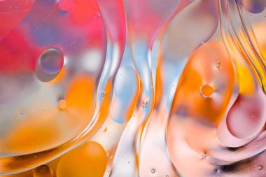 Su yüzeyindeki yağ damlacıklarının hareketine yakın çekim. Su yüzeyindeki yağ damlalarının renkli ve soyut makro arkaplanı