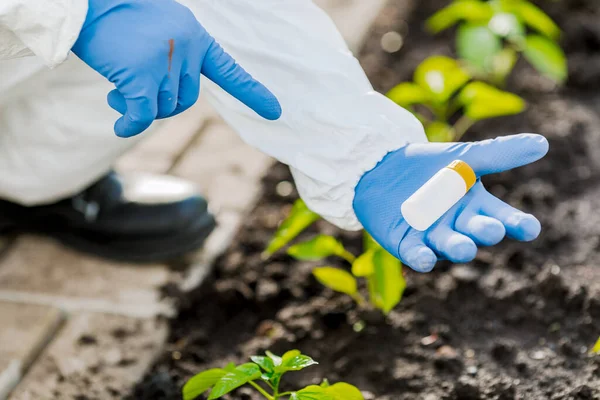 scientist\'s hand holds a jar of earth samples for analysis