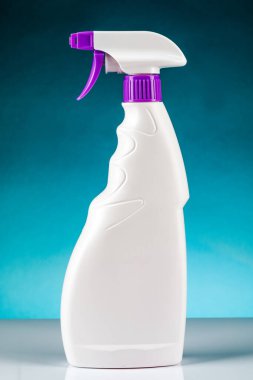 Sprey tabancayı temizlemek için plastik şişe. Mavi bir arkaplanda.