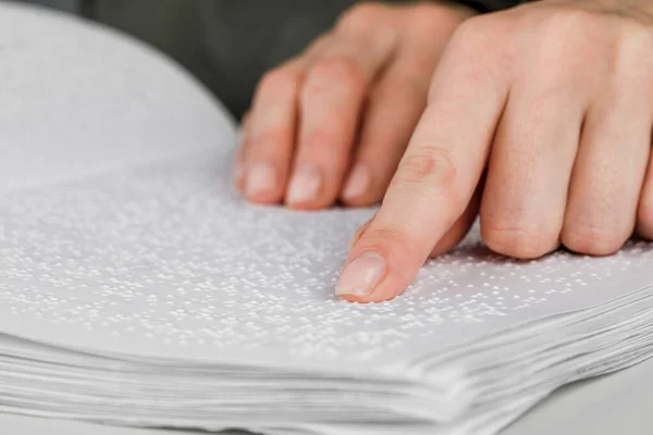 A woman reads a book written in Braille