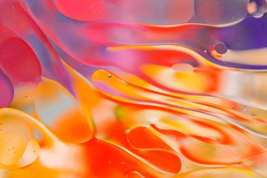 Su yüzeyindeki yağ damlacıklarının hareketine yakın çekim. Su yüzeyindeki yağ damlalarının renkli ve soyut makro arkaplanı
