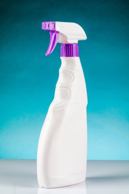 Sprey tabancayı temizlemek için plastik şişe. Mavi bir arkaplanda.