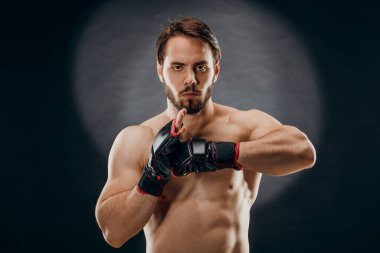 Boks eldivenli bir adam. Siyah arka planda boks yapan bir adam. Sağlıklı yaşam tarzı kavramı.