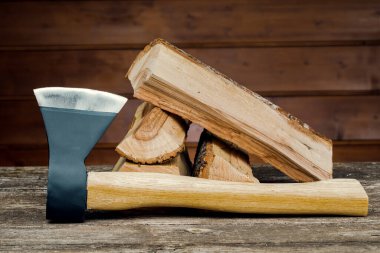 Axe and firewood, against the background of wooden boards. clipart
